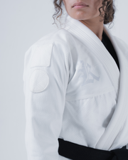 Kingz Born to Rule Women's Jiu Jitsu Gi White - Close-Up Detail View Female Athlete Embroidered Shoulder Patch Subtle Textured Fabric Black Belt Contrast Elegant Design BJJ Gi Training [color:White]