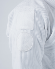 Kingz Born to Rule Women's Jiu Jitsu Gi White - Close-Up Detail View Shoulder Reinforced Stitching Square and Circle Patches Textured Fabric Durable Construction BJJ Gi Training [color:White]