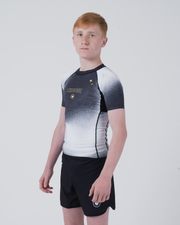 Kingz Galaxy Youth Rashguard Black White - Full Body 3/4 Angled Front View Teen Boy Athlete Short Sleeve Black White Galaxy Ombre Pattern Gold Star KINGZ Text Crown Logo Black Shorts