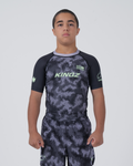 Kingz Viper Youth Rashguard Black Purple - Full Body Front View Teen Boy Athlete Short Sleeve Hexagonal Viper Scale Pattern KINGZ Text Green Crown Logo Purple Collar Matching Shorts Kids
