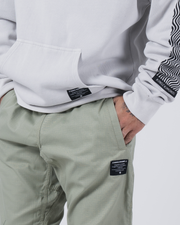 Kingz Casual Rip Stop Gi Pant - Stone Green - Close-Up Front View Male Model Sage Green Ripstop Fabric Black Kingz Patch Right Thigh Relaxed Fit BJJ Gi Pants [color:Stone Green]