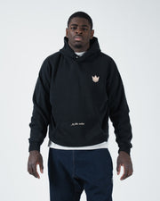 Black BJJ pullover hoodie front view on adult male model with crown logo and jiu jitsu motion script