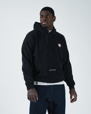 Black BJJ hoodie front pose on adult male model displaying boxy dual panel silhouette and crown emblem