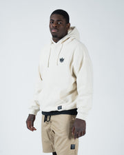 Beige BJJ hoodie front three-quarter view on adult male model showing crown logo and mid-weight fleece