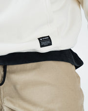 Beige BJJ hoodie bottom hem closeup of woven Kingz premium crafted gear crown label tag and ribbed hem
