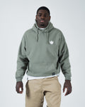 Dark forest green BJJ pullover hoodie front view on adult male model with white crown chest logo
