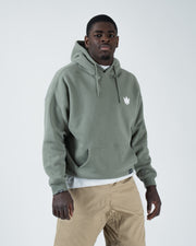 Dark forest green BJJ hoodie relaxed front pose on adult male model with crown logo and kangaroo pocket