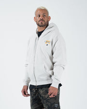 Grey BJJ zip up hoodie front three-quarter view on adult male model highlighting flag logo and zipper