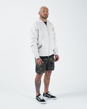 Grey BJJ zip up hoodie full body lifestyle shot with adult male model in camo shorts and black sneakers