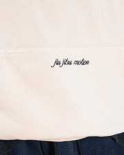 Peach BJJ hoodie pocket detail closeup of embroidered jiu jitsu motion cursive script above kangaroo pocket