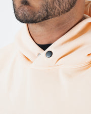 Peach BJJ hoodie neckline closeup showing metal snap button closure and dual panel collar construction