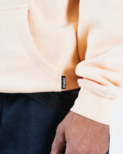 Peach BJJ hoodie hem detail closeup showing woven Kingz label tag and ribbed bottom hem and cuff