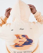 Peach BJJ hoodie back view on adult male model raising hood up over head above the Jiu Jitsu Motion print