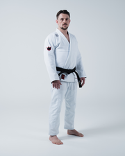 Kingz Ultralight 2.0 BJJ Gi White - Full Body Side Profile View Male Athlete White 420gsm Pearl Weave Gi Red Crown Logo Sleeve Patches
