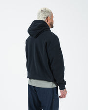 Black BJJ hoodie rear side profile on adult male model showing relaxed silhouette and ribbed hem detail