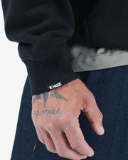 Black BJJ hoodie cuff detail closeup showing ribbed cuff with Kingz print and hem stitching construction