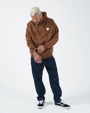 Chestnut brown BJJ hoodie full body lifestyle shot with adult male model in dark jeans and black shoes