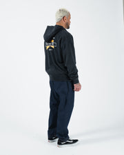 Black BJJ zip up hoodie full body rear side profile with adult male model showing back print and jeans