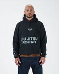 Black BJJ pullover hoodie front view on adult male model showing Jiu Jitsu Squad chest print and pocket
