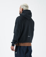 Black BJJ pullover hoodie back view on adult male model showing clean rear panel and drawstring hood