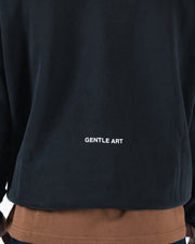Black BJJ hoodie back detail closeup showing Gentle Art screen print across lower rear panel fabric