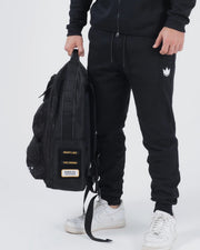Kingz Tactical Backpack Black - Lifestyle Side Carry - Held by Handle Patches Visible - BJJ Gear Bag
