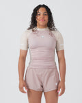 Kingz Terra Women's Rashguard Soil Edition - Full Body Front View Female Athlete Short Sleeve Dusty Rose Mauve Body Cream Beige Raglan Sleeves White Crown Logo Chest KINGZ White Text Sleeve Matching Dusty Rose Hybrid Shorts Women's BJJ No-Gi