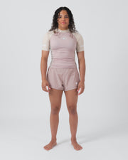 Kingz Terra Women's Rashguard Soil Edition - Full Body Front View Female Athlete Short Sleeve Dusty Rose Mauve Body Cream Beige Raglan Sleeves Crown Logo KINGZ Text Matching Mauve Hybrid Shorts Barefoot Stance Women's BJJ Terra Collection