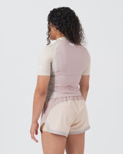 Kingz Terra Women's Rashguard Soil Edition - Full Body Back View Female Athlete Short Sleeve Dusty Rose Mauve Body Cream Beige Raglan Sleeves White Crown Logo Upper Back Matching Hybrid Shorts Cream Beige Body Mauve Trim Women's BJJ