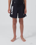 Kingz Kore V2 Youth Shorts Black - Full Body Front View Teen Boy Athlete Solid Black Bold Vertical KINGZ White Text Left Leg Circular Crown Badge Right Competition Cut Kids Grappling Shorts No-Gi BJJ Kore Collection [color:Black]