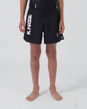 Kingz Kore V2 Youth Shorts Black - Full Body Front View Teen Boy Athlete Solid Black Bold Vertical KINGZ White Text Left Leg Circular Crown Badge Right Competition Cut Kids Grappling Shorts No-Gi BJJ Kore Collection [color:Black]