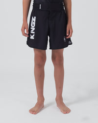 Kingz Kore V2 Youth Shorts Black - Full Body Front View Teen Boy Athlete Solid Black Bold Vertical KINGZ White Text Left Leg Circular Crown Badge Right Competition Cut Kids Grappling Shorts No-Gi BJJ Kore Collection [color:Black]