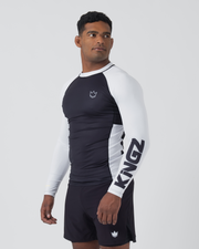 Kingz Ranked Performance V2 L/S Rashguard Navy White - Full Body 3/4 Front Right Side View Male Athlete Long Sleeve Navy Body White Right Sleeve KINGZ Bold Black Text Sleeve Crown Logo Chest Navy Shorts Performance Fit