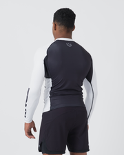 Kingz Ranked Performance V2 L/S Rashguard Navy White - Full Body 3/4 Back View Male Athlete Long Sleeve Navy Body White Sleeve KINGZ Bold Text White Crown Logo Upper Back Navy Shorts BJJ Competition Performance