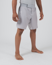 Kingz Ghost Grappling Shorts Silver Gray - Full Body Left Side Profile Male Athlete Light Silver Gray Black Stripe Waistband Detail Side Split Visible Competition Cut Men's Grappling Shorts No-Gi BJJ