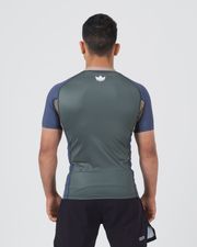 Kingz Draft Rashguard Storm Blue - Full Body Straight Back View Male Athlete Short Sleeve Crown Logo Centered Upper Back Gray Body Blue Raglan Sleeves Side Accent Stripes Black Shorts