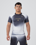 Kingz Galaxy Rash Guard Black White - Full Body Front View Male Athlete Short Sleeve Black To White Ombre Galaxy Pattern Gold Star Detail KINGZ Gold Text Crown Logo Matching Galaxy Pattern Spats BJJ MMA Training