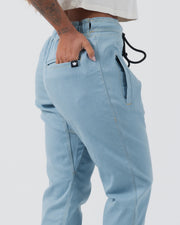 Kingz Casual Gi Pant Light Denim - Close-Up Side View Tattooed Female Hand Elastic Waistband Black Drawstring Crown Logo Pocket Stitch Detail BJJ Gi Training Apparel [color:Light Denim]