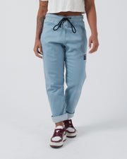 Kingz Casual Gi Pant Light Denim - Front View Female Model Black Drawstring Rolled Cuffs Kingz Patch Left Thigh Relaxed Fit BJJ Gi Training Apparel [color:Light Denim]