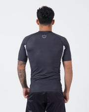 Kingz Ranked Performance V2 S/S Rashguard Dark Charcoal White - Full Body Back View Male Athlete Short Sleeve Dark Gray Body White Crown Logo Upper Back White Side Panels IBJJF Cuff Wrist Matching Dark Shorts BJJ Performance Fit
