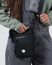 Kingz Side Bag Black - Waist Level Action Shot - Strap in Hand Crown Logo Visible - BJJ Crossbody Bag