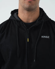 Kingz Canvas Jacket Black - Close-Up Front View Male Model Black Zip-Up Hoodie KINGZ Text Left Chest Drawstring Hood Streetwear Casual Apparel [color:Black]
