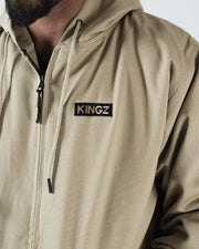 Kingz Canvas Jacket Desert - Close-Up Front View Male Model Tan Fabric KINGZ Text Chest Patch Drawstring Hood Streetwear [color:Desert]