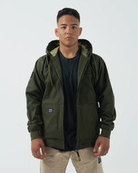 Kingz Canvas Jacket Military Green - Front View Male Model Hooded Design Black KINGZ Chest Logo Dual Front Pockets Ribbed Cuffs Streetwear Style Casual Apparel [color:Black]