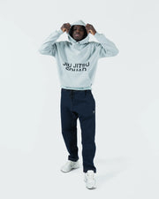 Sea foam green BJJ hoodie full body lifestyle shot with adult male model styled with joggers and sneakers