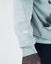Sea foam green BJJ hoodie sleeve detail closeup showing Kingz Originals arm graphics and ribbed cuff
