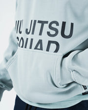 Sea foam green BJJ hoodie closeup detail of Jiu Jitsu Squad print and kangaroo pocket with hand tucked