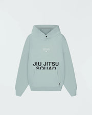 Sea foam green BJJ hoodie full length rear three-quarter view on adult male model in relaxed street pose