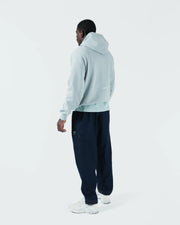 Sea foam green BJJ hoodie full body rear lifestyle shot with adult male model showing back and joggers