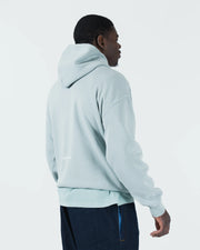 Sea foam green BJJ hoodie rear side profile on adult male model showing relaxed drape and hood detail